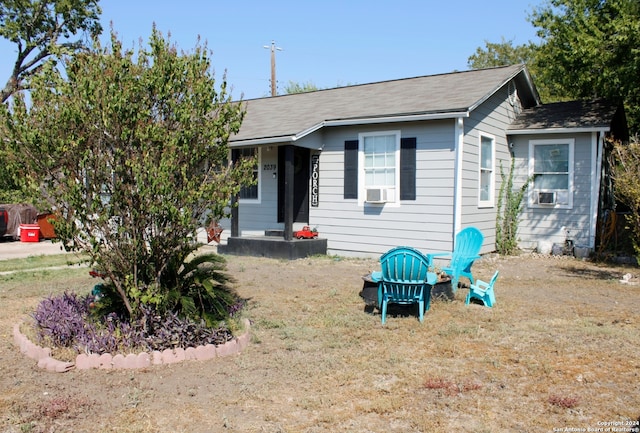 view of front of home with a front yard and cooling unit