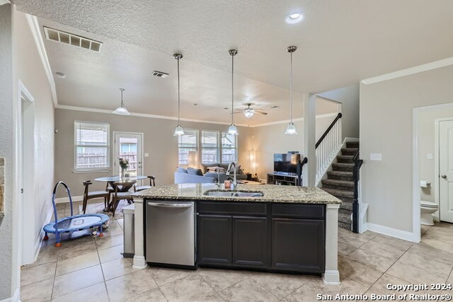 kitchen featuring decorative light fixtures, a kitchen island with sink, crown molding, stainless steel dishwasher, and sink