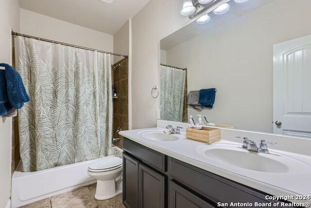 full bathroom featuring shower / bathtub combination with curtain, tile patterned flooring, toilet, and vanity