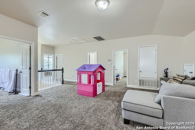 recreation room with carpet and vaulted ceiling