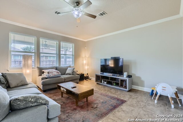 tiled living room featuring ceiling fan and ornamental molding