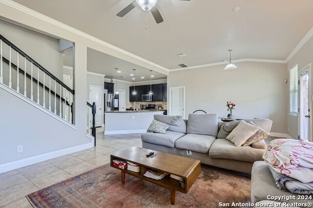 tiled living room featuring crown molding and ceiling fan