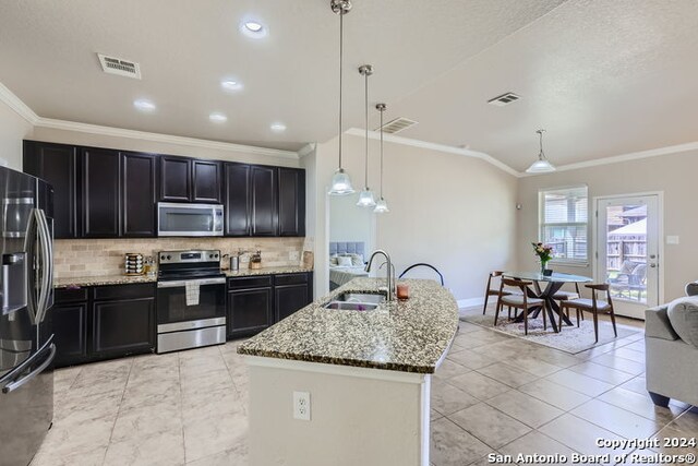 kitchen featuring hanging light fixtures, sink, appliances with stainless steel finishes, and tasteful backsplash