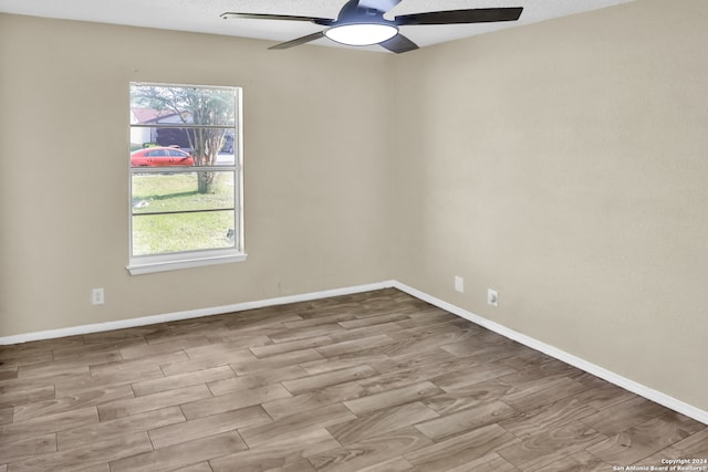 empty room with hardwood / wood-style floors, ceiling fan, and a wealth of natural light