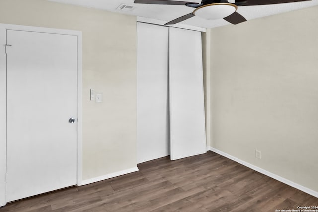 unfurnished bedroom featuring ceiling fan, a closet, and dark hardwood / wood-style flooring