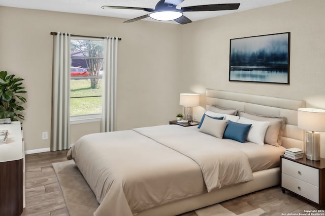 bedroom with multiple windows, ceiling fan, and light hardwood / wood-style floors