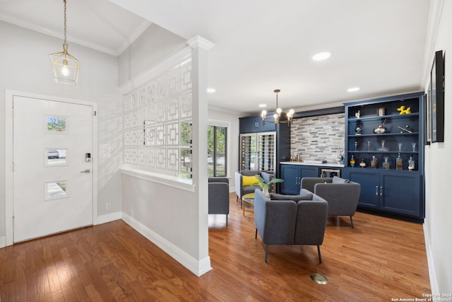 entryway featuring wood-type flooring, an inviting chandelier, and crown molding