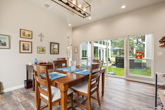 dining space featuring a wealth of natural light, hardwood / wood-style floors, and a chandelier