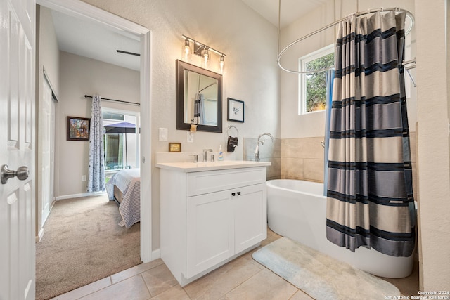 bathroom featuring vanity, shower / bath combo with shower curtain, and tile patterned flooring