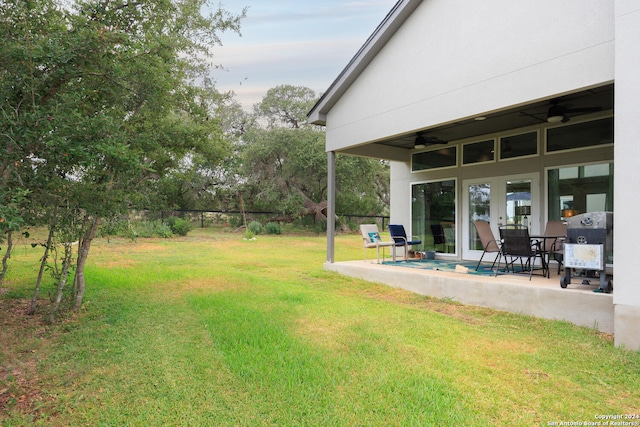 view of yard featuring ceiling fan and a patio