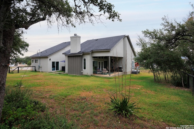 rear view of house with a patio area and a lawn