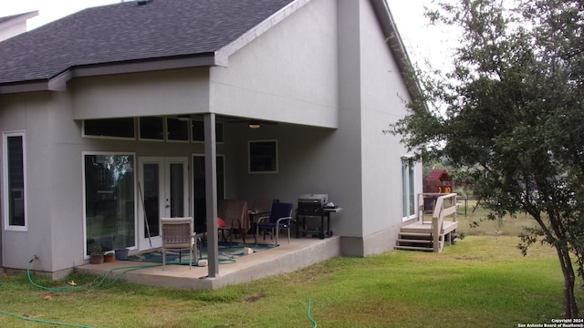 back of house with a lawn and a patio area