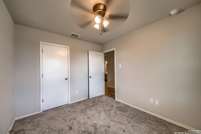 unfurnished bedroom featuring carpet flooring, ceiling fan, and a closet