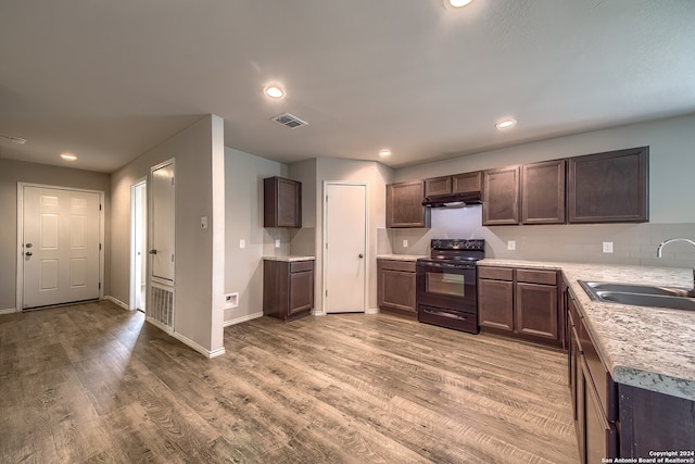 kitchen featuring dark brown cabinets, sink, electric range, and light hardwood / wood-style floors