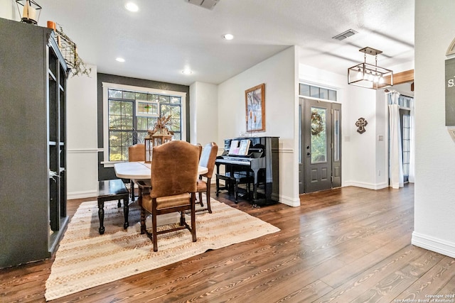 dining area featuring a textured ceiling and dark hardwood / wood-style flooring