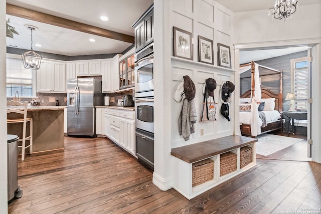 kitchen with white cabinetry, stainless steel appliances, beamed ceiling, and dark hardwood / wood-style flooring