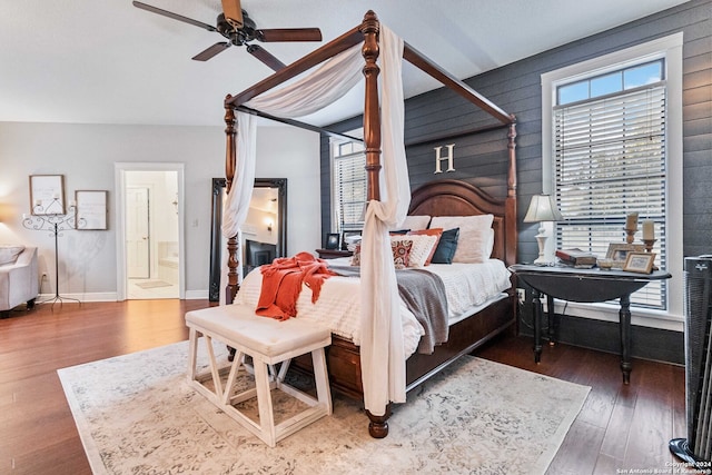 bedroom with ensuite bathroom, ceiling fan, and dark hardwood / wood-style floors