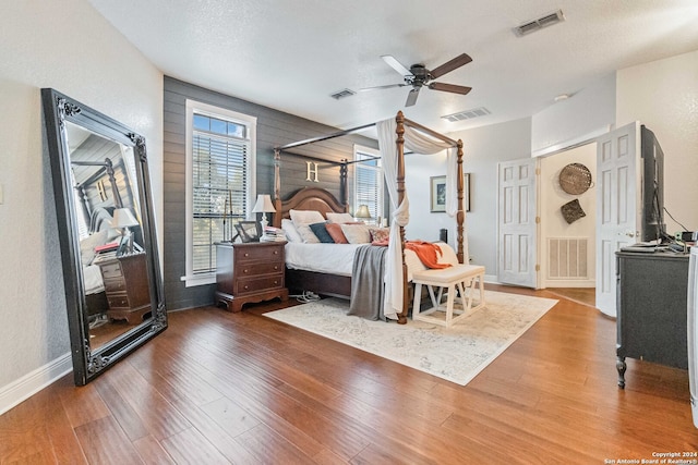 bedroom featuring hardwood / wood-style floors, ceiling fan, and a textured ceiling