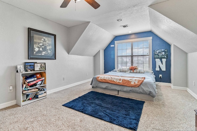 bedroom featuring a textured ceiling, carpet flooring, ceiling fan, and vaulted ceiling