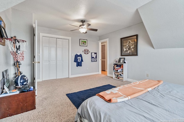 carpeted bedroom with a textured ceiling, ceiling fan, and a closet