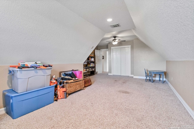 bonus room featuring lofted ceiling, ceiling fan, carpet floors, and a textured ceiling