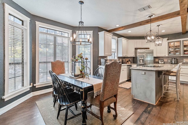 dining area with dark hardwood / wood-style floors, beamed ceiling, and a chandelier