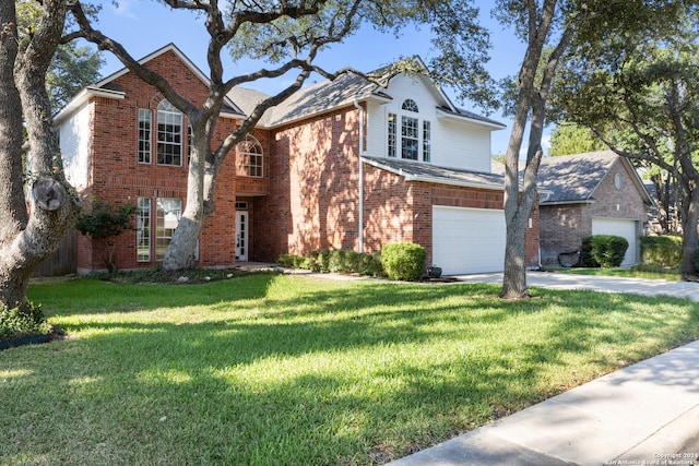 view of property featuring a front yard and a garage