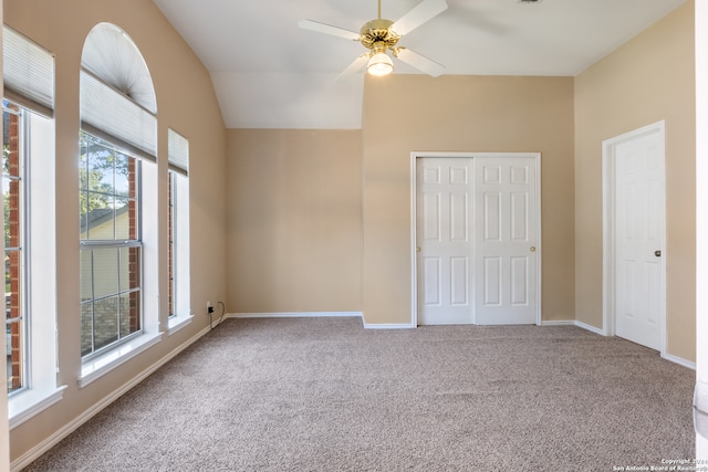 unfurnished bedroom with ceiling fan, carpet floors, and lofted ceiling