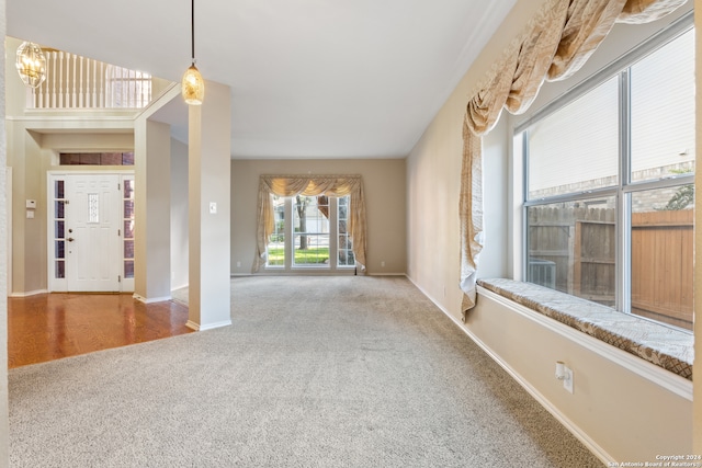 carpeted entryway featuring a chandelier