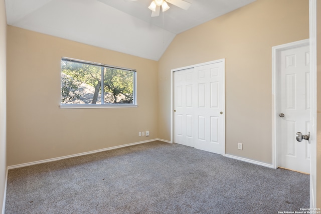 unfurnished bedroom featuring ceiling fan, a closet, carpet, and vaulted ceiling