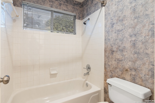 bathroom featuring tiled shower / bath combo and toilet