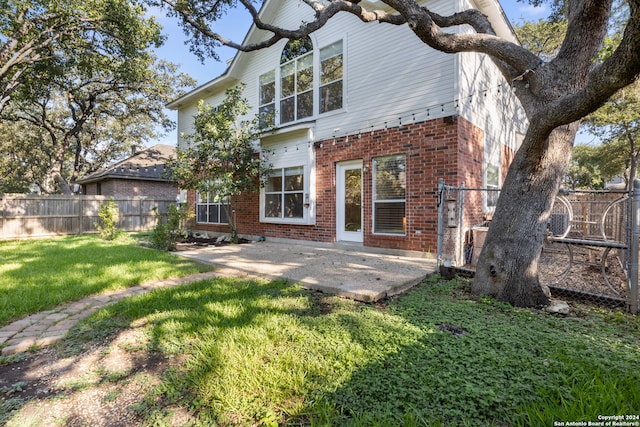 back of property featuring a lawn and a patio area