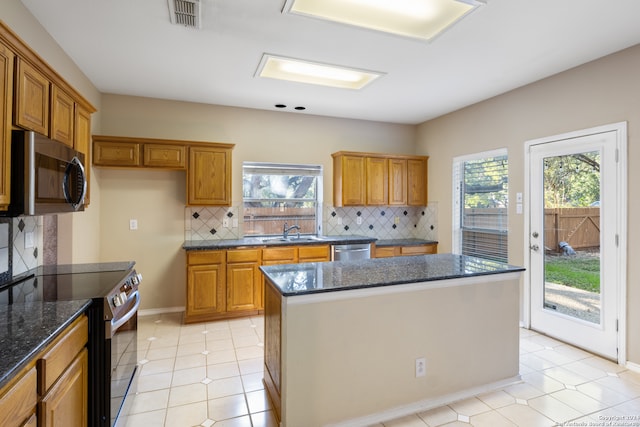 kitchen featuring a wealth of natural light, a center island, appliances with stainless steel finishes, and tasteful backsplash