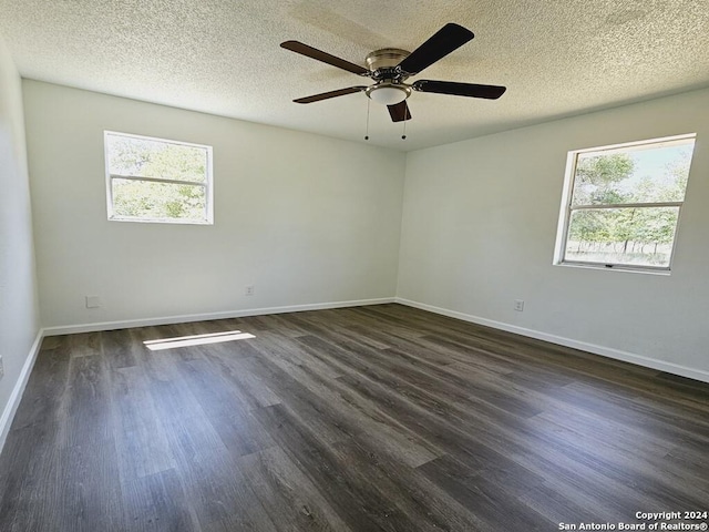 unfurnished room featuring plenty of natural light, baseboards, and dark wood-type flooring