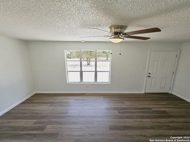 unfurnished room featuring dark wood-type flooring, ceiling fan, a textured ceiling, and baseboards