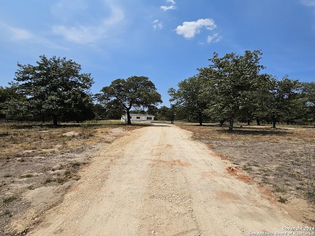 view of road featuring a rural view and dirt driveway