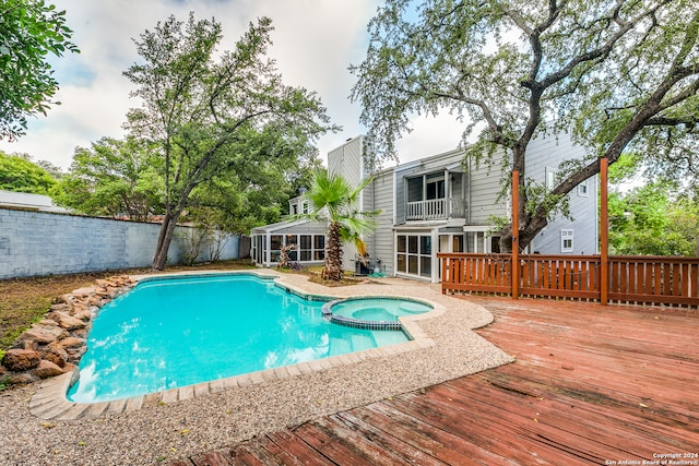 view of pool with an in ground hot tub and a deck