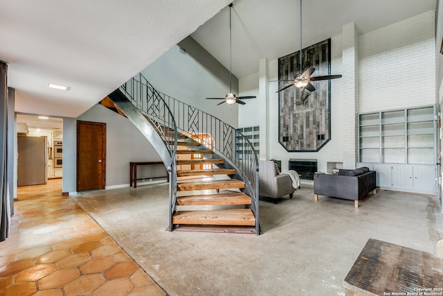 stairs featuring ceiling fan and a high ceiling