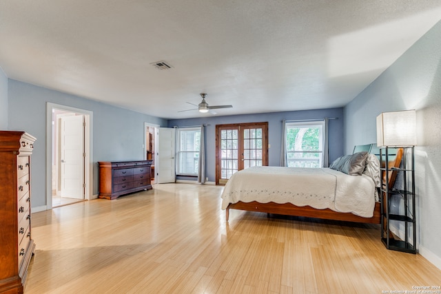 bedroom with light wood-type flooring, french doors, and ceiling fan