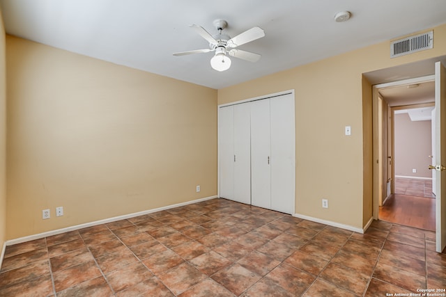 unfurnished bedroom featuring ceiling fan and a closet