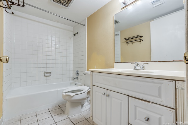 full bathroom with tile patterned flooring, toilet, tiled shower / bath combo, and vanity