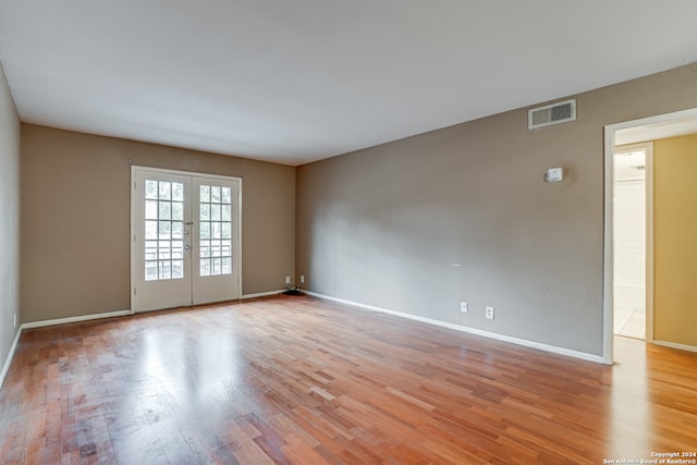 unfurnished room with french doors and light hardwood / wood-style floors