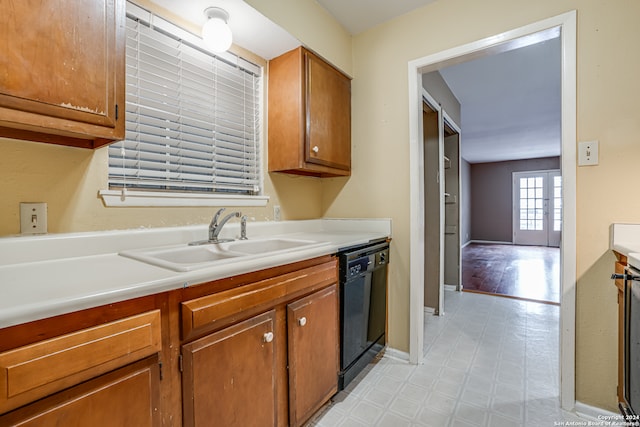 kitchen with black dishwasher, light hardwood / wood-style floors, and sink