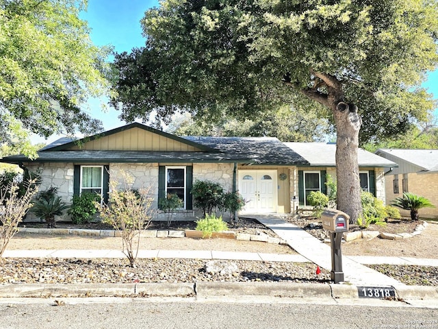 ranch-style house with stone siding and board and batten siding