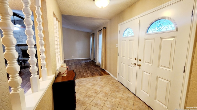 entrance foyer with light tile patterned floors and a textured ceiling