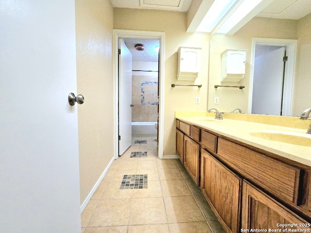 full bathroom with baseboards, double vanity, a sink, and tile patterned floors