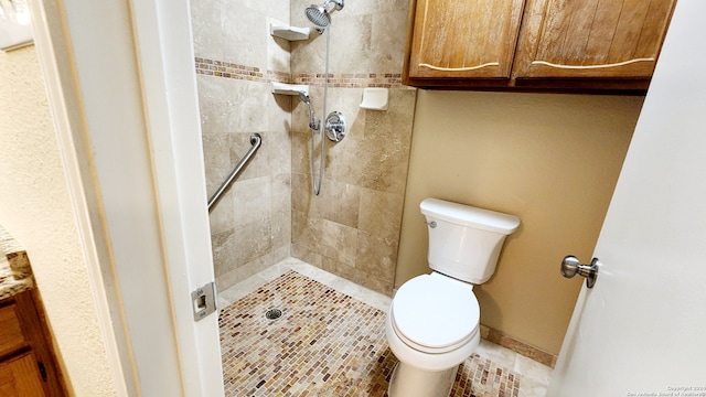 bathroom featuring a tile shower and toilet