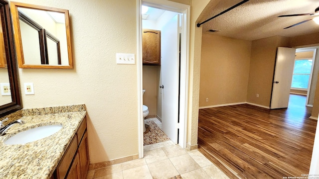 full bath with visible vents, toilet, a ceiling fan, a textured ceiling, and wood finished floors