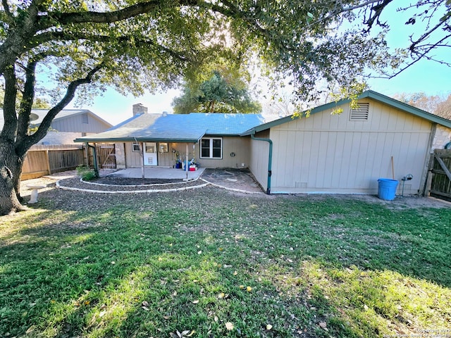 rear view of house featuring a yard and a patio