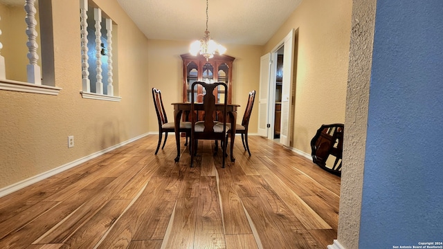 dining area featuring wood-type flooring and an inviting chandelier